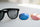 Scratched sunglass lenses beside new replacement lenses in blue and rose mirror