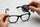 How to replace sunglass lenses at home: holding a new replacement lens above the frame before snapping it in